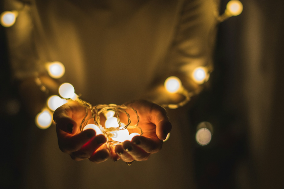 Luzes de Natal em tom abstrato, remetendo às festas de fim de ano e um ambiente acolhedor.