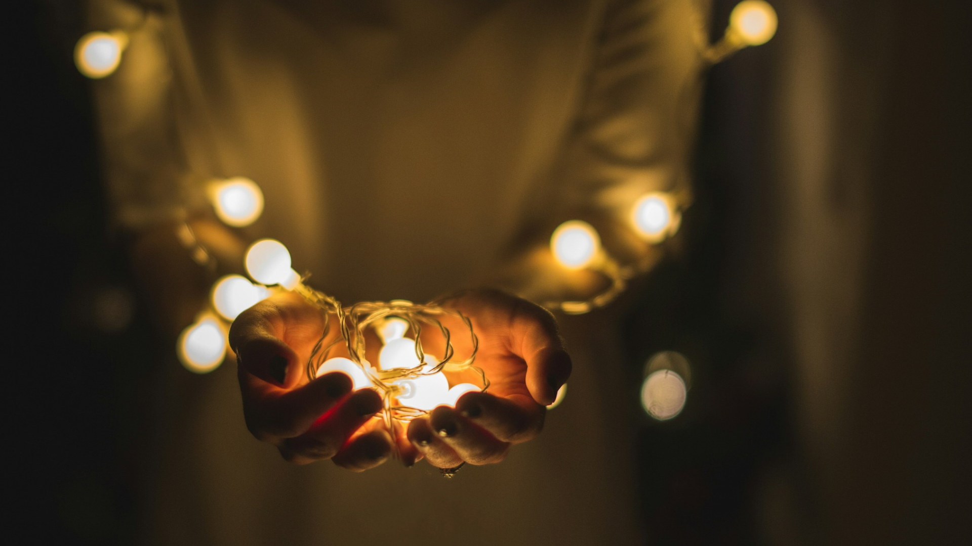 Luzes de Natal em tom abstrato, remetendo às festas de fim de ano e um ambiente acolhedor.